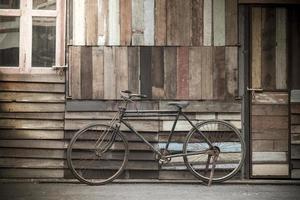 bicicleta vintage de pie cerca de una pared de madera vintage foto