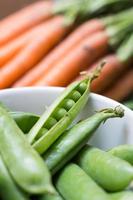 Pea pods in a bowl with carrots photo