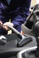 Man Hoovering Seat Of Car During Car Cleaning photo