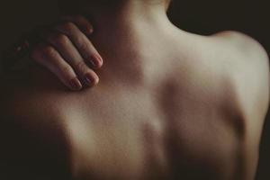 Nude woman with a shoulder injury photo