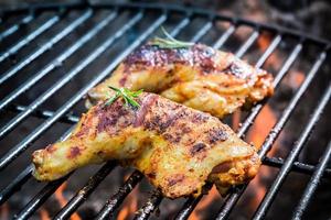 Roasted chicken legs on the grill with fire photo