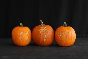 Three Pumpkins carved with Hawaiian signs photo