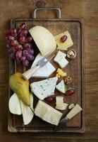 tabla de quesos con quesos variados (parmesano, brie, azul, cheddar)