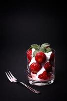 Fresa fresca y menta con crema en un vaso foto