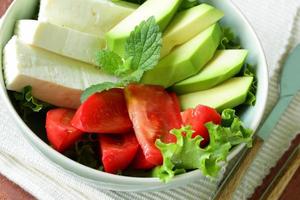 salad in asian style with tofu cheese, avocado and tomato photo