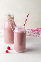 Glass and bottle of cherry smoothie