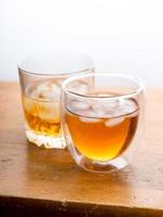 whiskey in glasses on wooden table photo