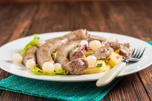 Vienna sausages with potato salad and pickled onions photo