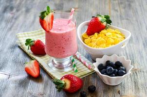 desayuno saludable con copos de maíz, batido de fresa y blueb