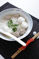 comida vietnamita, bola de pescado y fideos de arroz pho en sopa foto