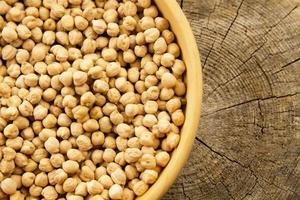 bunch of chickpeas in bowl on old wooden background