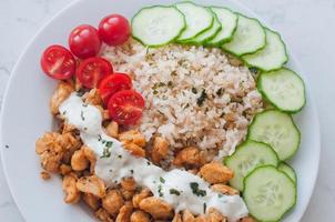 Gyros chicken with rice, tzatziki dressing and vegetables photo