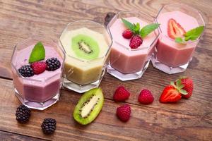 Drink smoothies summer strawberry, blackberry, kiwi, raspberry on wooden table. photo