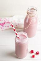 Glass and bottle of cherry smoothie