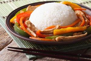 Arroz chino con pollo y verduras closeup en un plato