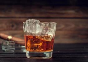 Glass of whiskey with ice and cigar photo