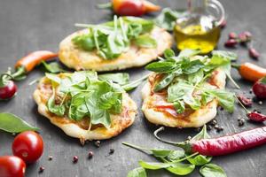 mini pizzas con mozzarella, espinacas y albahaca fresca foto