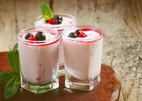 Homemade yogurt with berry juice and currants in a glass photo