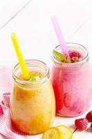 Carrot banana and raspberry shake on wooden table photo