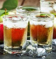 Cool refreshing apple juice with ice and fruit