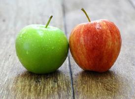 manzana roja y verde sobre fondo de madera