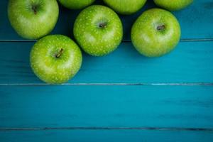 cultivar manzanas verdes orgánicas frescas en la mesa de madera retro foto