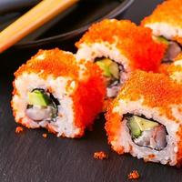rollo de sushi con cangrejo, aguacate, pepino y tobiko.