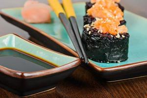 Baked sushi rolls served on turquoise plate photo