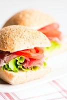 Prosciutto sandwich with tomato and arugula selective focus
