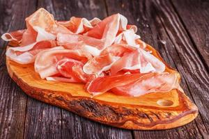 Prosciutto served on a olive cutting board