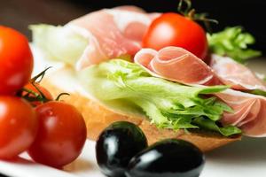 Ham sandwich with tomato and olive close up