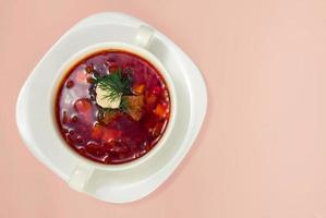 Borsch in white plate isolated on white. Beetroot soup background.