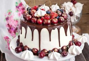 Cake decorated with chocolate, meringues and fresh berries