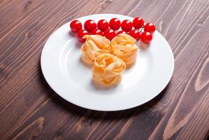 pasta raw three slices and sprig cherry tomatoes photo