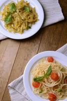 Deliciosos espaguetis con tomates en placa en primer plano de la mesa foto