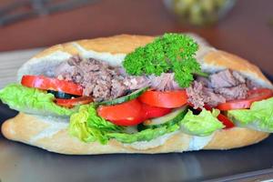 Tuna Baguette With Vegetables On The Brown Plate photo