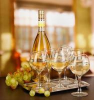 White wine in glass and bottle on room background
