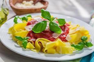 Homemade pappardelle pasta with tomato sauce and basil photo