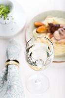 copa de vino blanco con pasta de mariscos foto