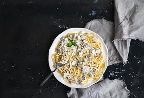 Pasta spaghetti with creamy mushroom sauce and basil in white photo