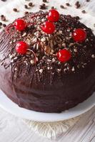 chocolate cake with cherries and nuts. Vertical closeup