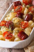 pasta baked with cherry tomatoes and sausages closeup vertical