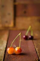 Red and yellow cherries on wooden background photo