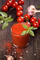 Tomato juice and fresh cherry tomatoes on table