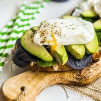 Healthy sandwich with avocado and poached eggs photo