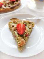 homemade cake with strawberries , rhubarb and cashew nuts photo