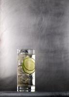 cocktail with ice and lime on metal background