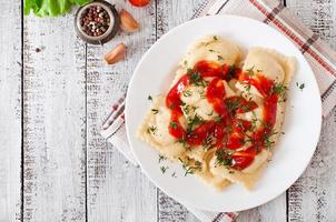 Delicious ravioli with tomato sauce and dill photo
