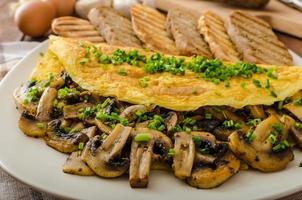 Rustic omelette with mushrooms on chives photo