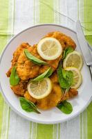 Fried schnitzel with herbs and lemon photo